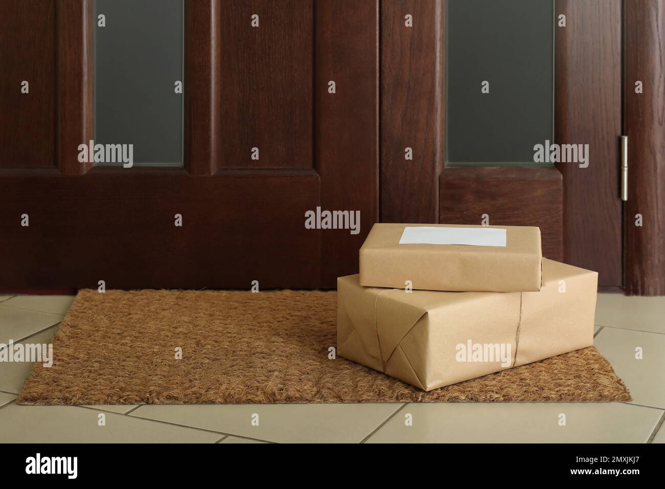 Parcels on rug near door. Delivery service Stock Photo Alamy