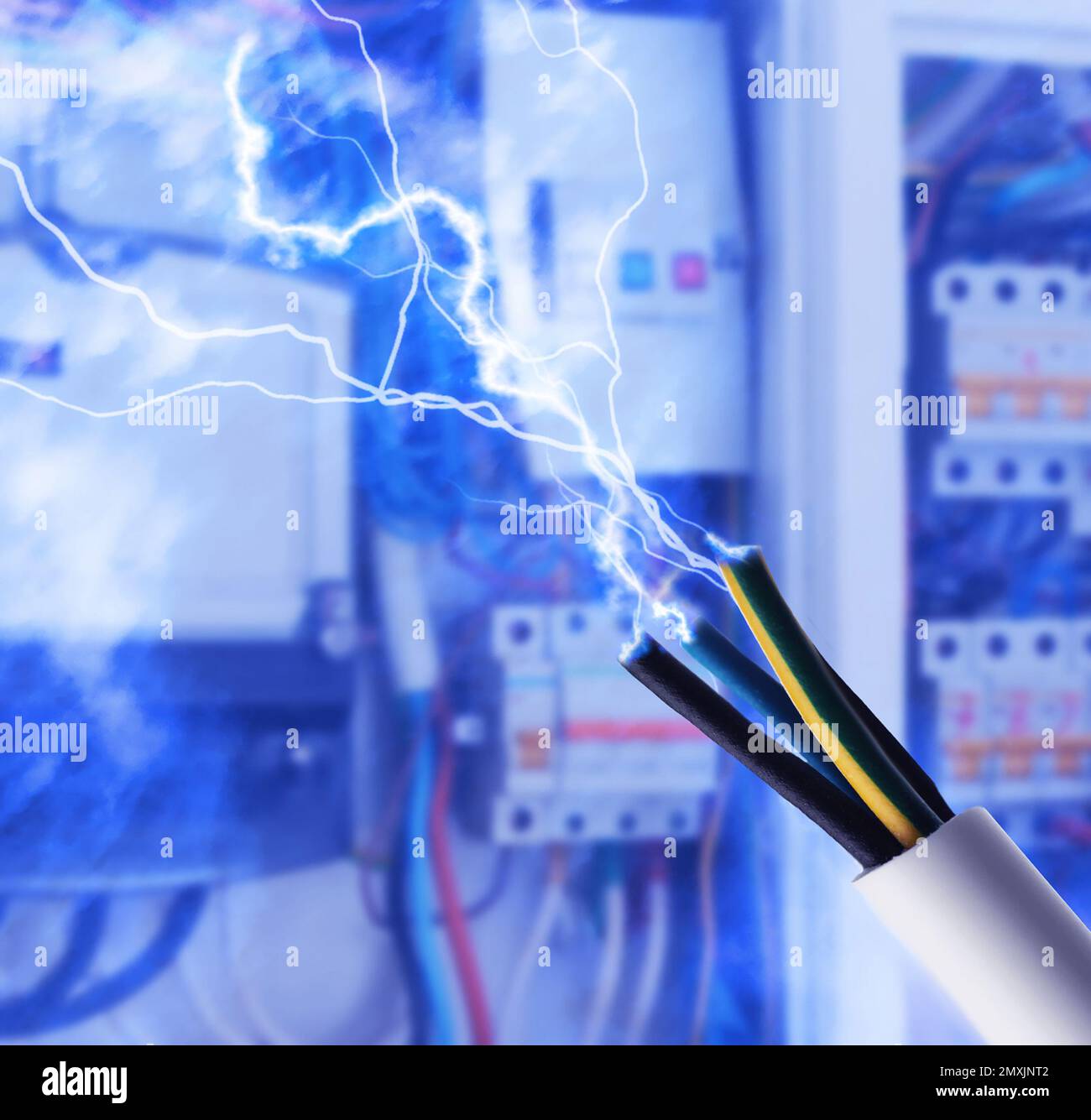 Sparking cables against blurred electric cabinet, closeup Stock Photo