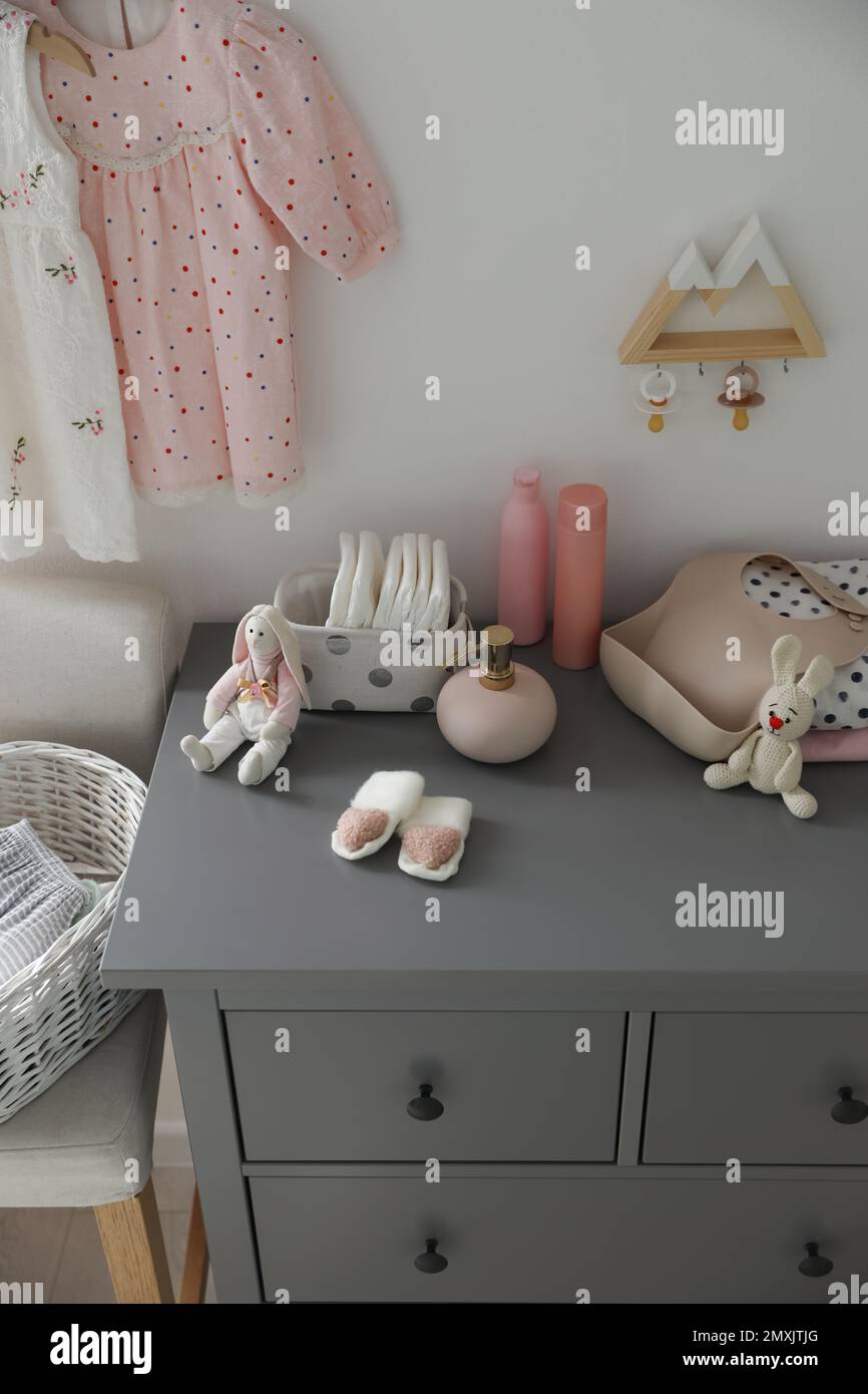 Stylish chest of drawers and accessories in child room Stock Photo