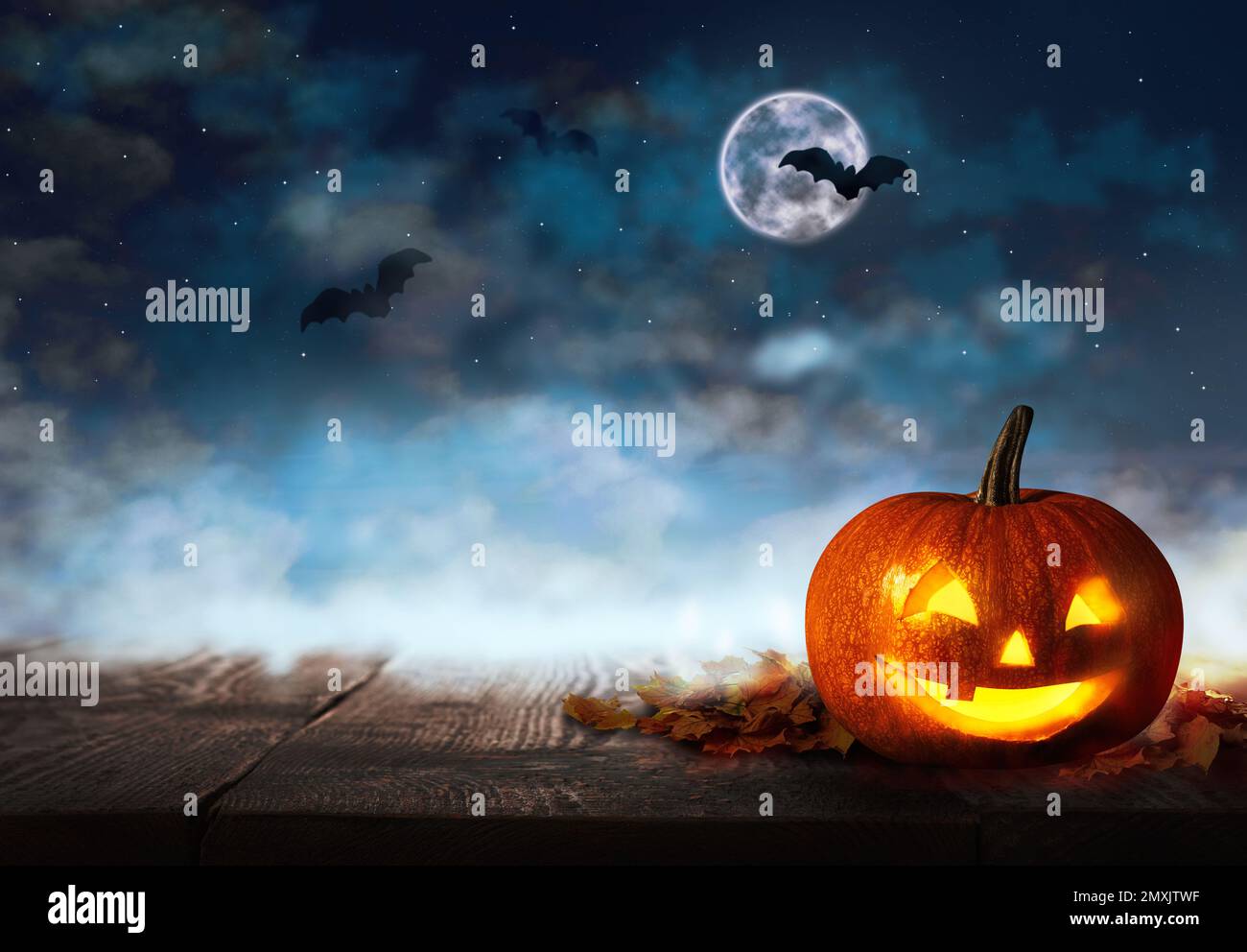 Spooky Jack O Lantern pumpkin under dark sky with flying bats and full ...