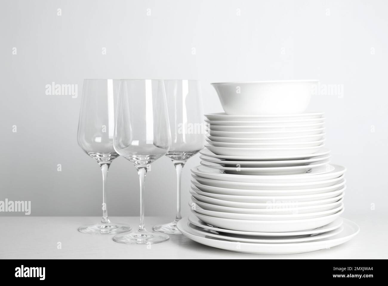 Stack white clean plates and other metal utensils on the shelves in commercial  restaurant. Stock Photo by ©andreonegin 315743746