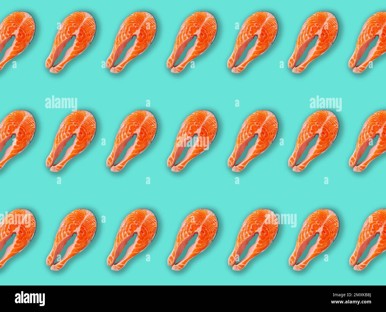 Minimalist pattern made of raw fresh fish salmon steak top view on blue clean background from above, delicacy healthy fish eating and nutrition concep Stock Photo