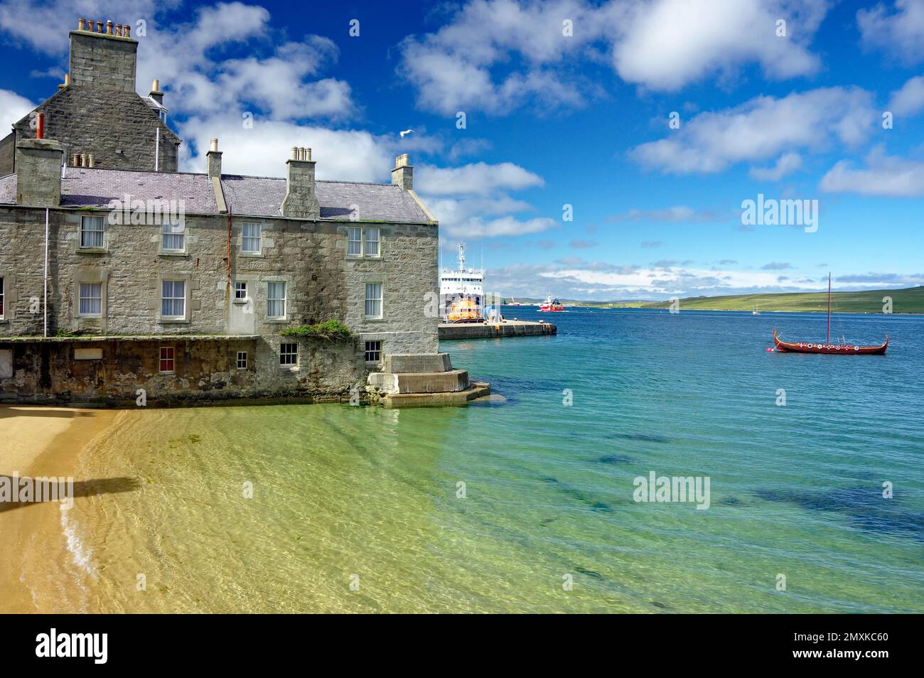 Quiet bay with crystal clear water, harbour, stone house and Viking ship Lerwick, Shetland Islands, Scotland, United Kingdom, Europe Stock Photo