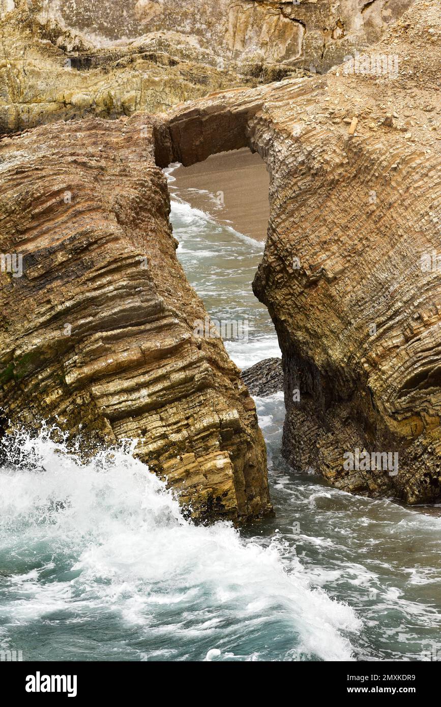 Sandstone arch over Pacific Ocean with waves crashing, Montana de Oro State Park, Southern California. Stock Photo