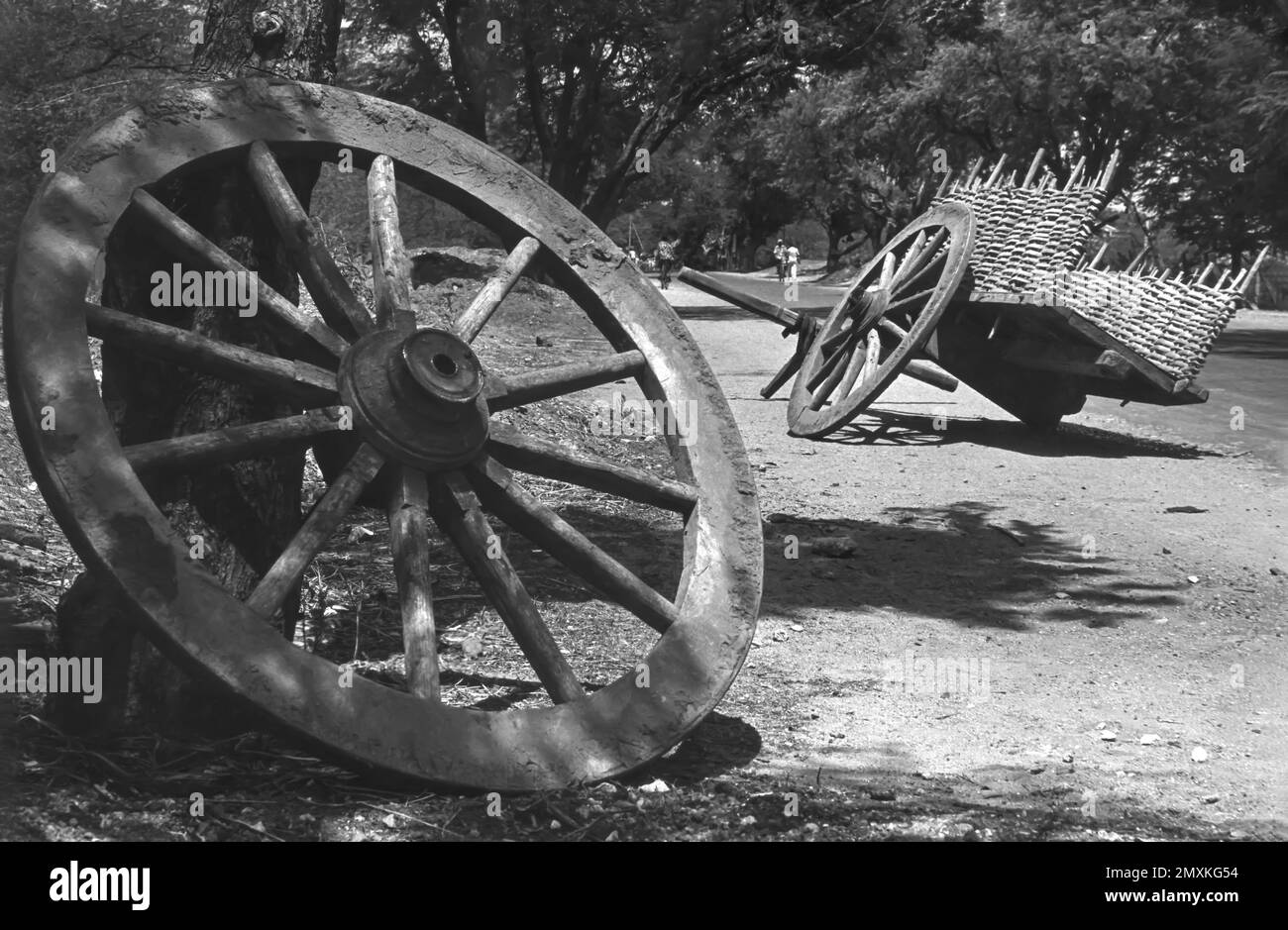 black and white photo, Wooden cart wheel and a damaged cart on road in Coimbatore, Tamil Nadu, India, Asia. Photographed in 1980, Asia Stock Photo
