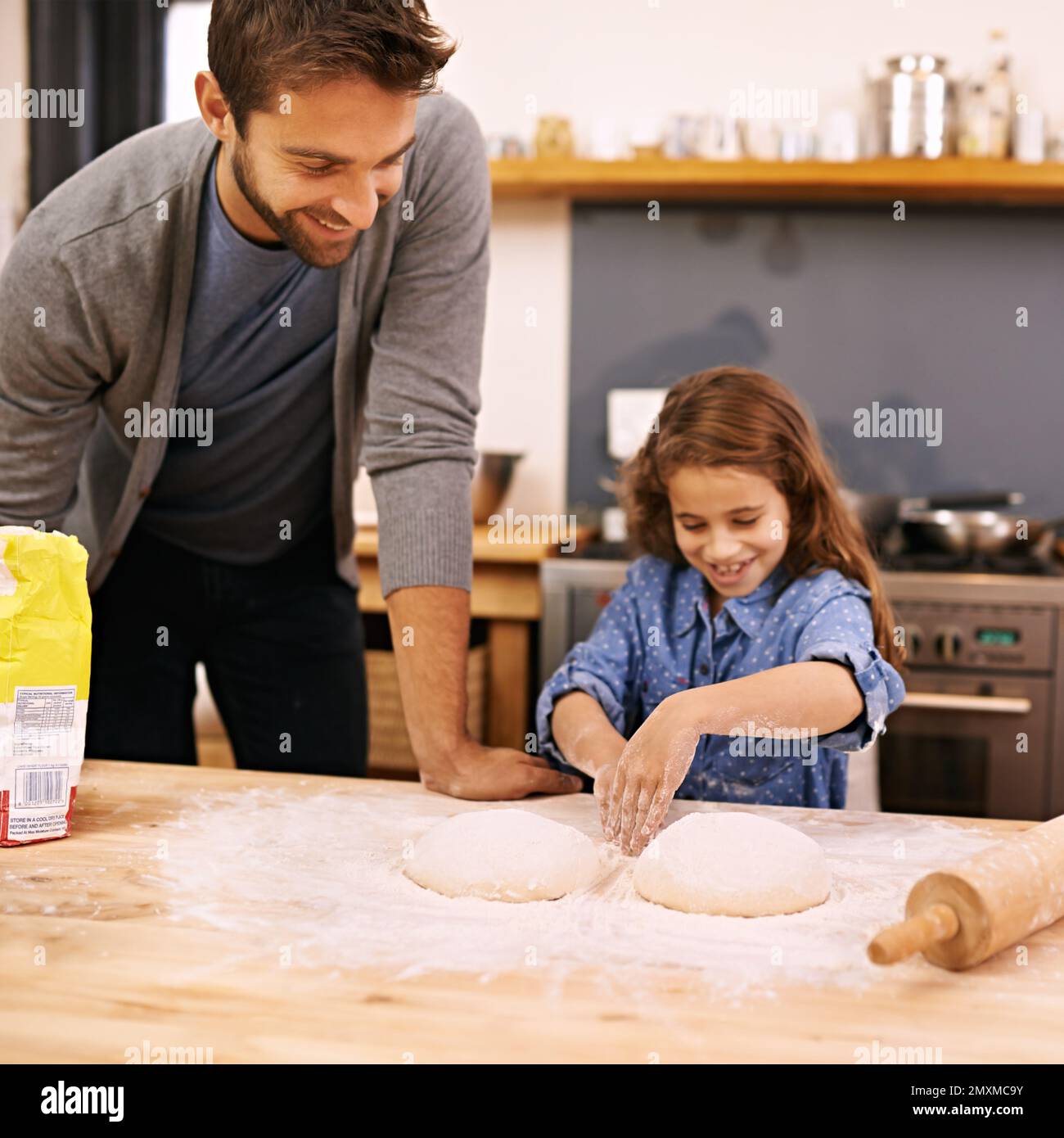 Learning to cook is fun. a father and daughter working with pizza dough