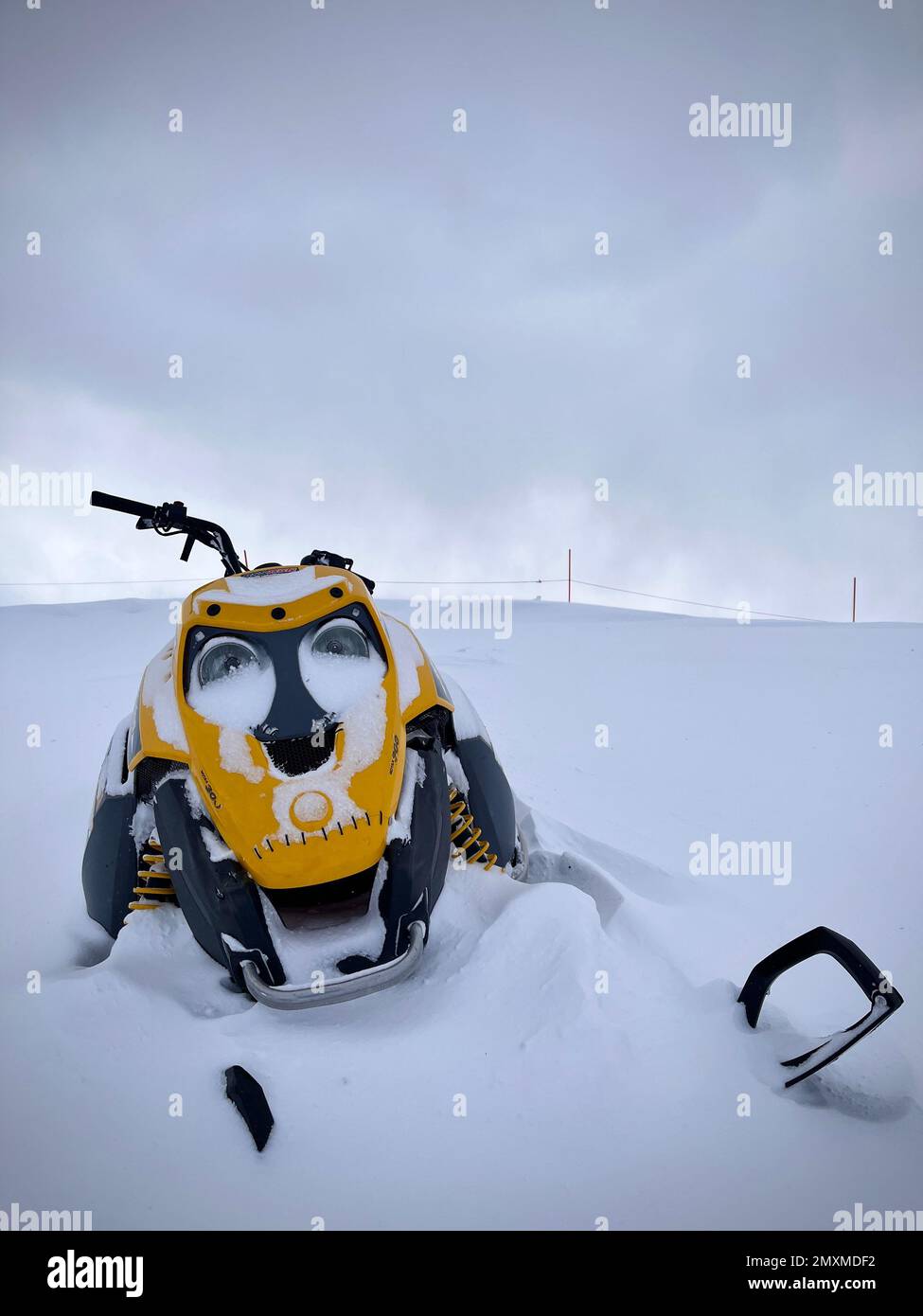 Yellow snowmobile parked in deep snow Stock Photo Alamy