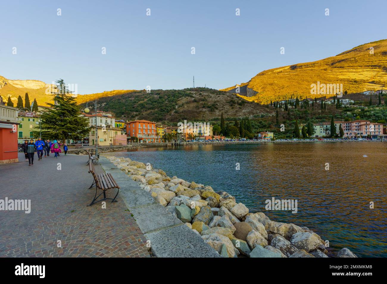 Nago–Torbole, Italy - February 26, 2022: View of the north shore of Lake Garda, with locals and visitors, on a clear winter day, in Nago–Torbole, Tren Stock Photo