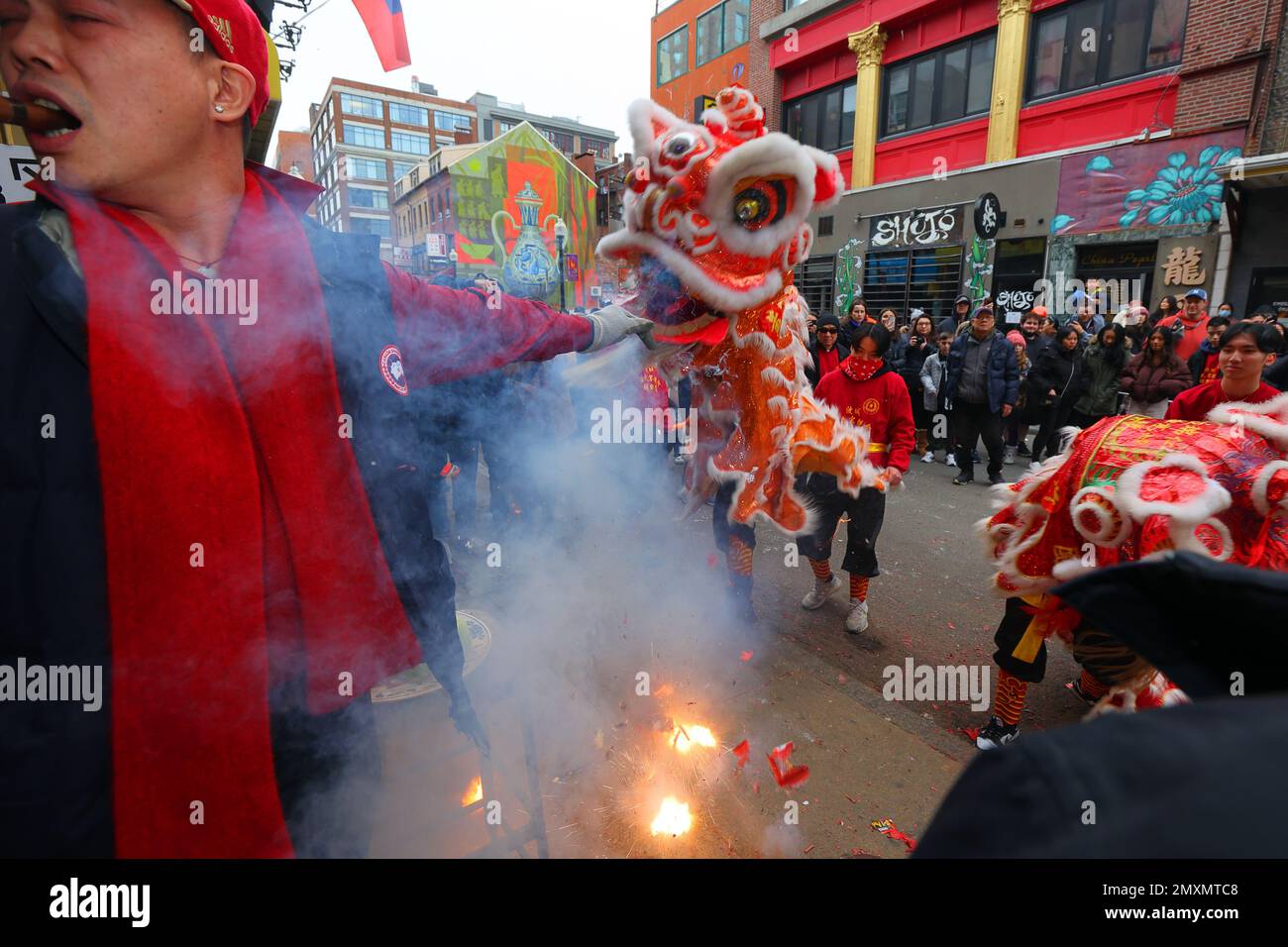 Wong Family Benevolent Lion Dance Team and exploding firecrackers in Boston Chinatown during Spring Festival, Chinese New Year, January 29, 2023. Stock Photo