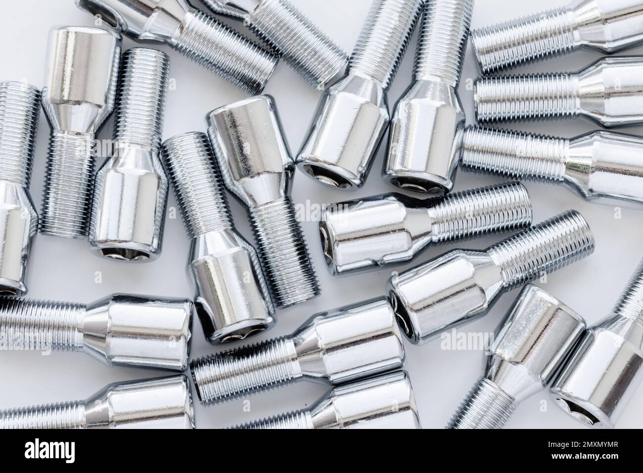 shiny steel chrome coated wheel bolts on white background, fullframe
