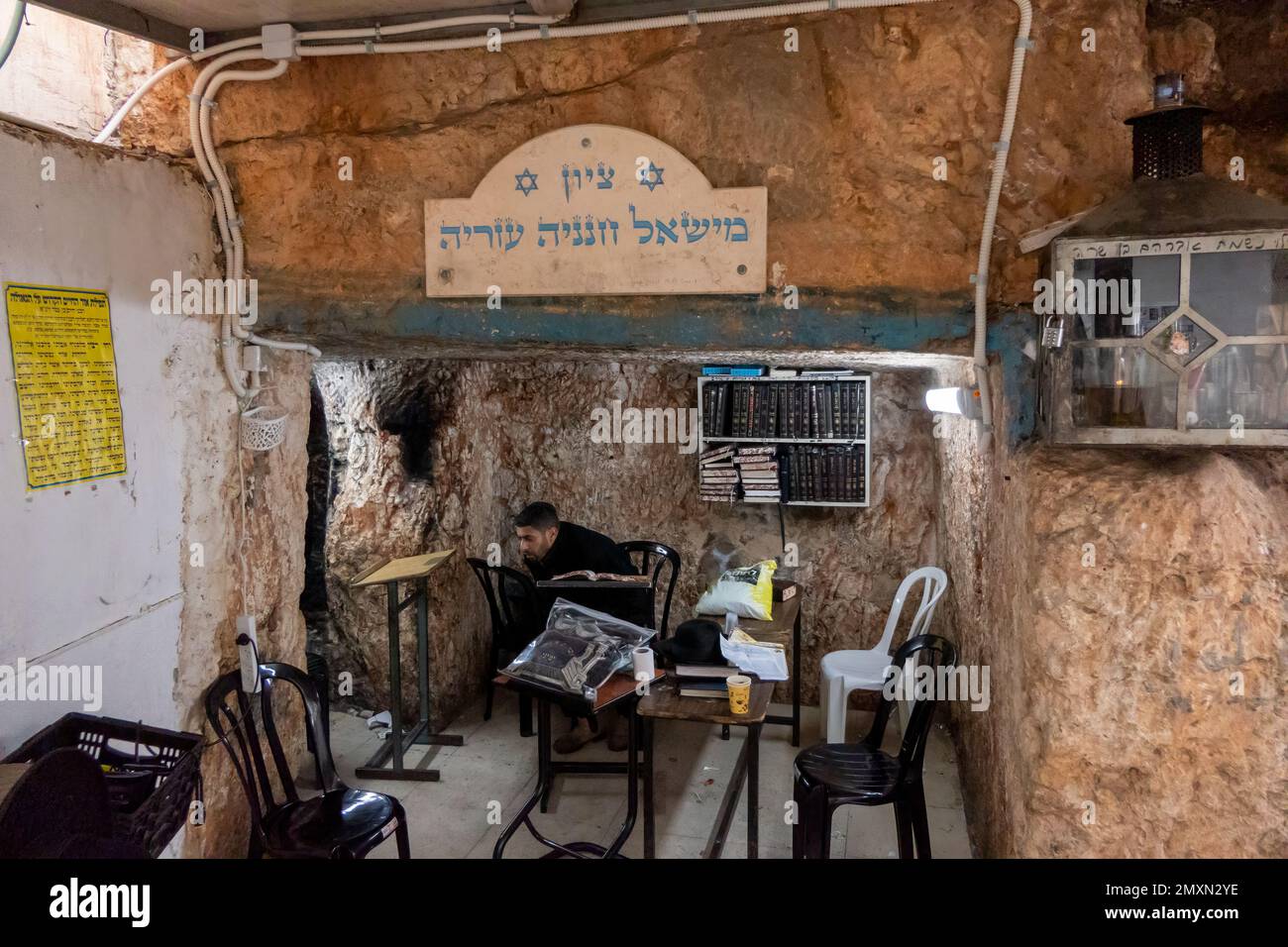 A religious Jew sits inside the Tomb of Simeon the Just or Simeon the
