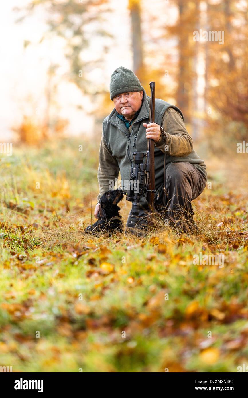 Portrait of hunter or ranger with a hunting gun and hunting form to