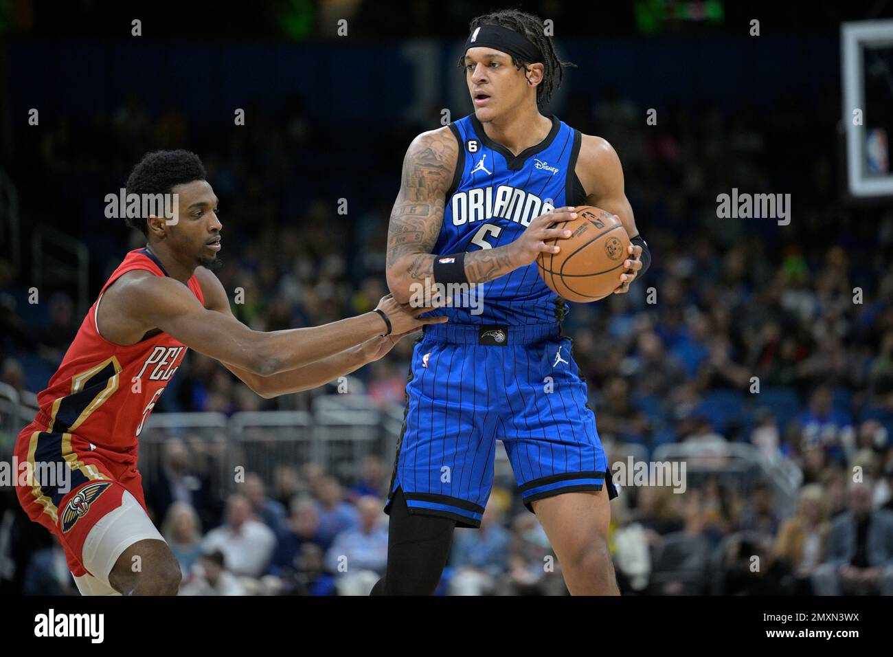 Orlando Magic forward Paolo Banchero (5), right, is defended by New