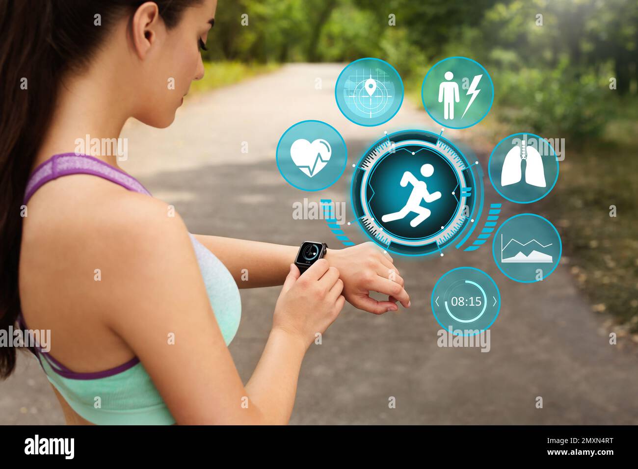 Woman using smart watch during training outdoors. Icons near hand with device Stock Photo