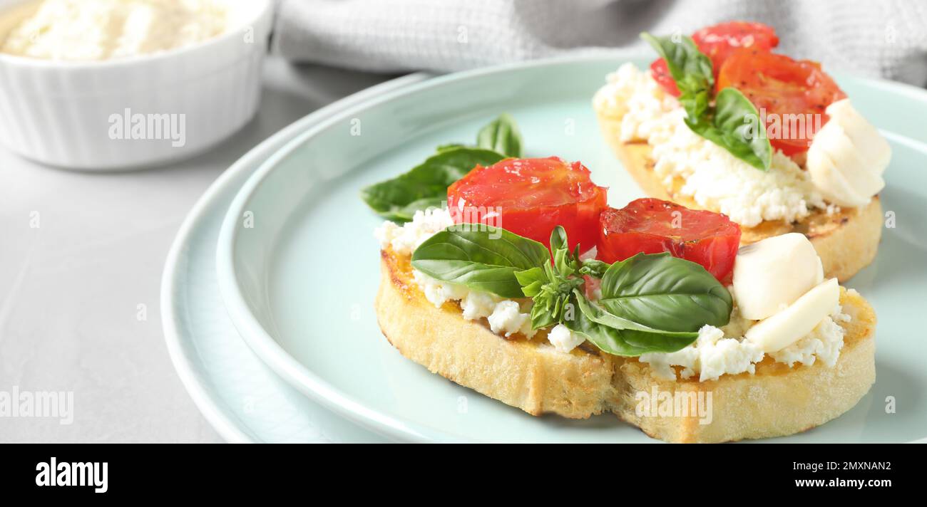 Tasty bruschettas with tomato on grey table, closeup. Banner design Stock Photo