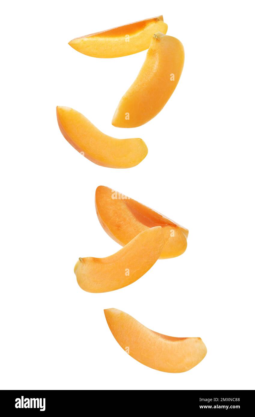 Ripe apricot slices falling on white background Stock Photo