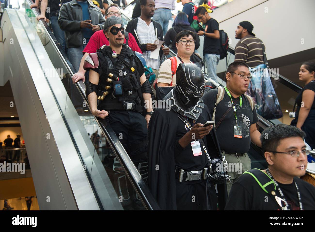 Costumed characters ride the escalator during New York Comic Con at the ...