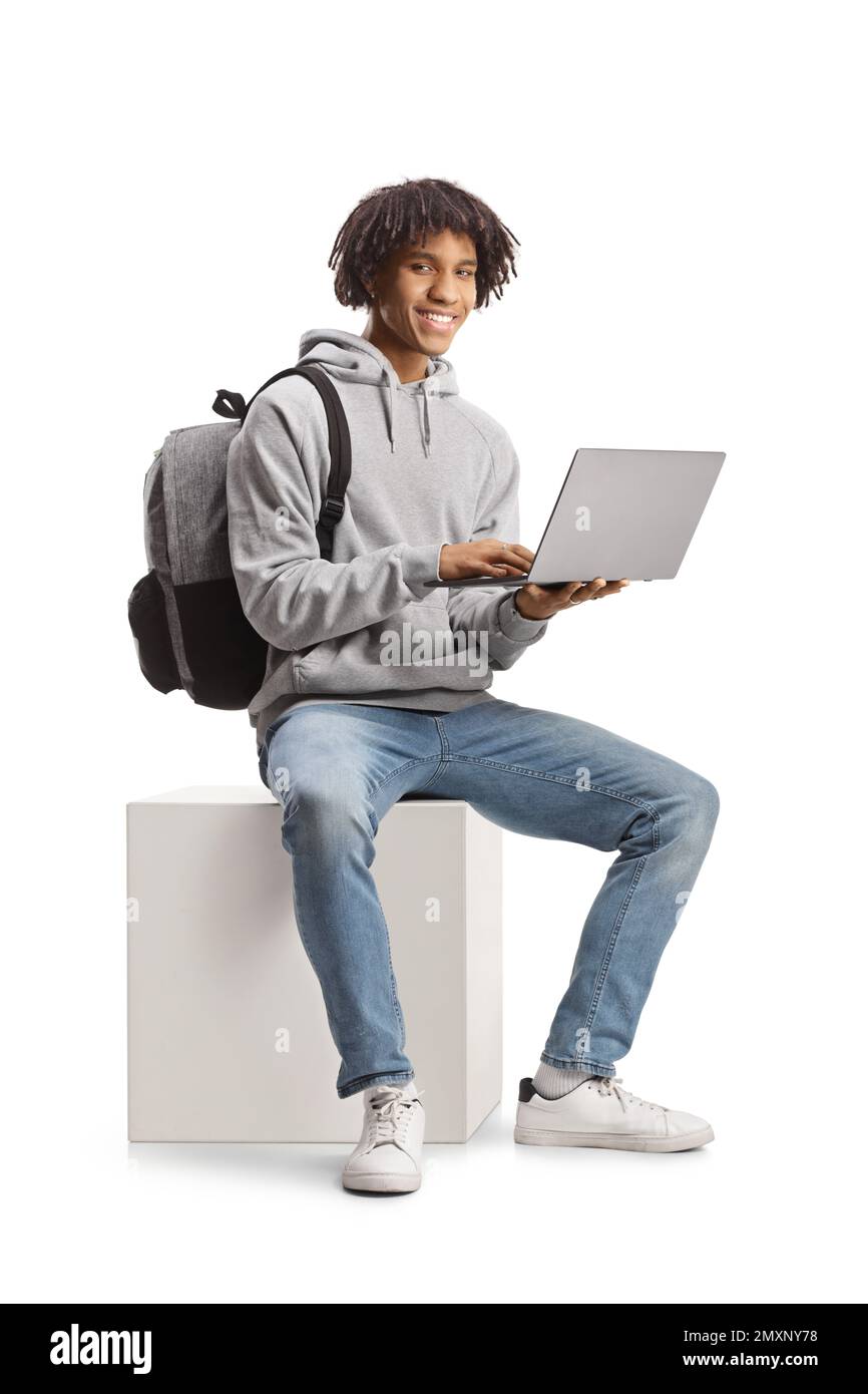 Male african american student sitting with a laptop computer and smiling at camera isolated on white background Stock Photo