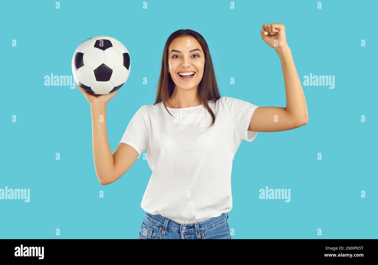 Beautiful excited female football fan actively supports her favorite football team. Stock Photo
