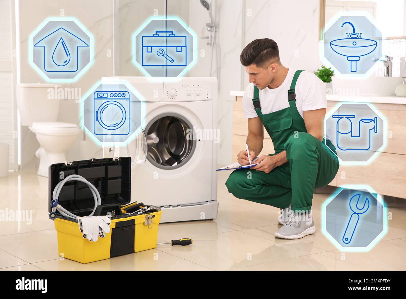 Sanitary engineering service. Professional plumber repairing washing machine in bathroom Stock