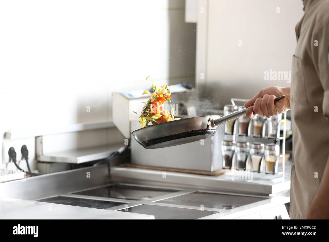 Male chef cooking tasty food on stove in restaurant Stock Photo - Alamy