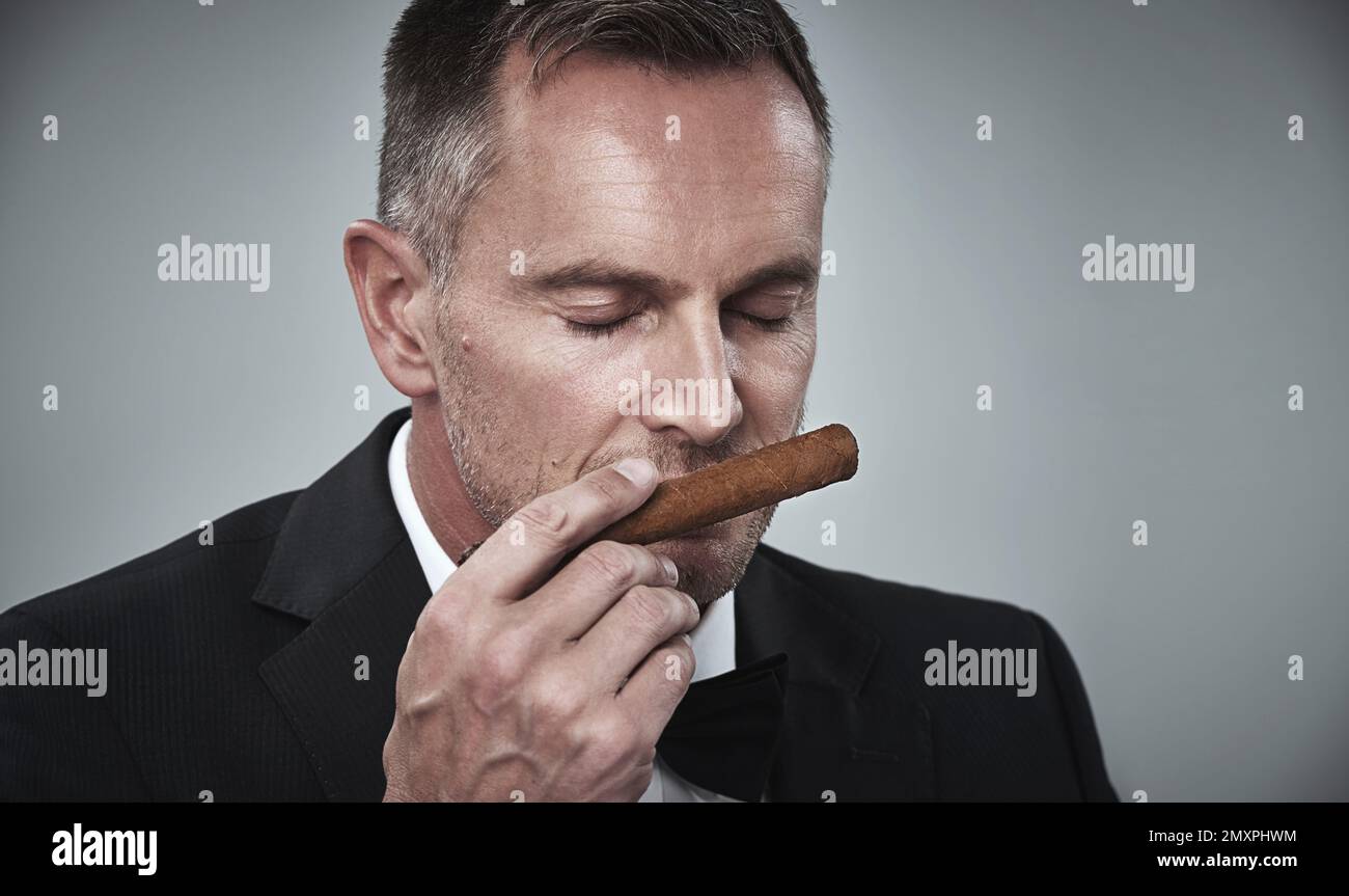Suit, luxury and man smell cigars for smoking habit on gray background
