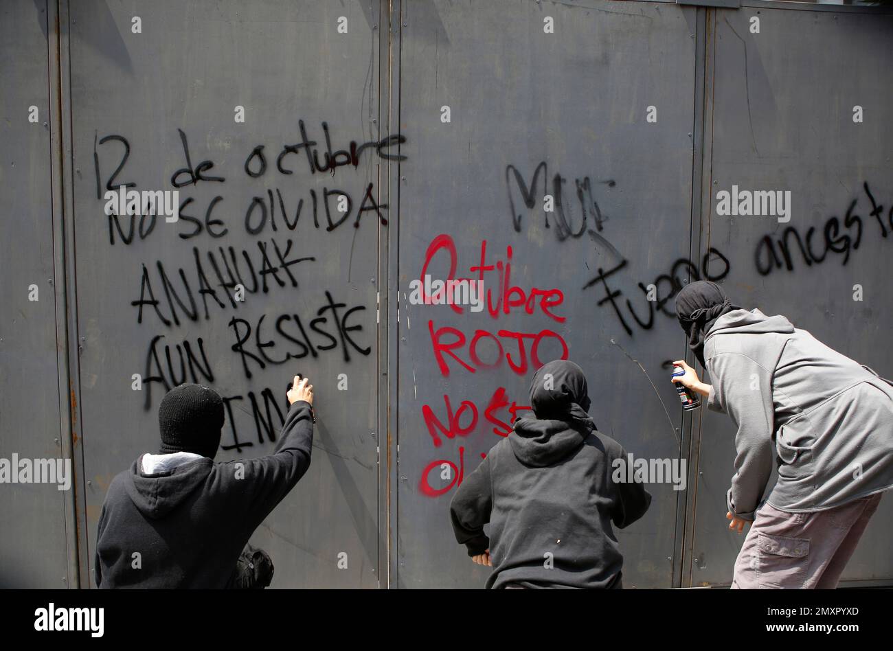 Men spray paint slogans calling for Oct. 2 to not be onto a