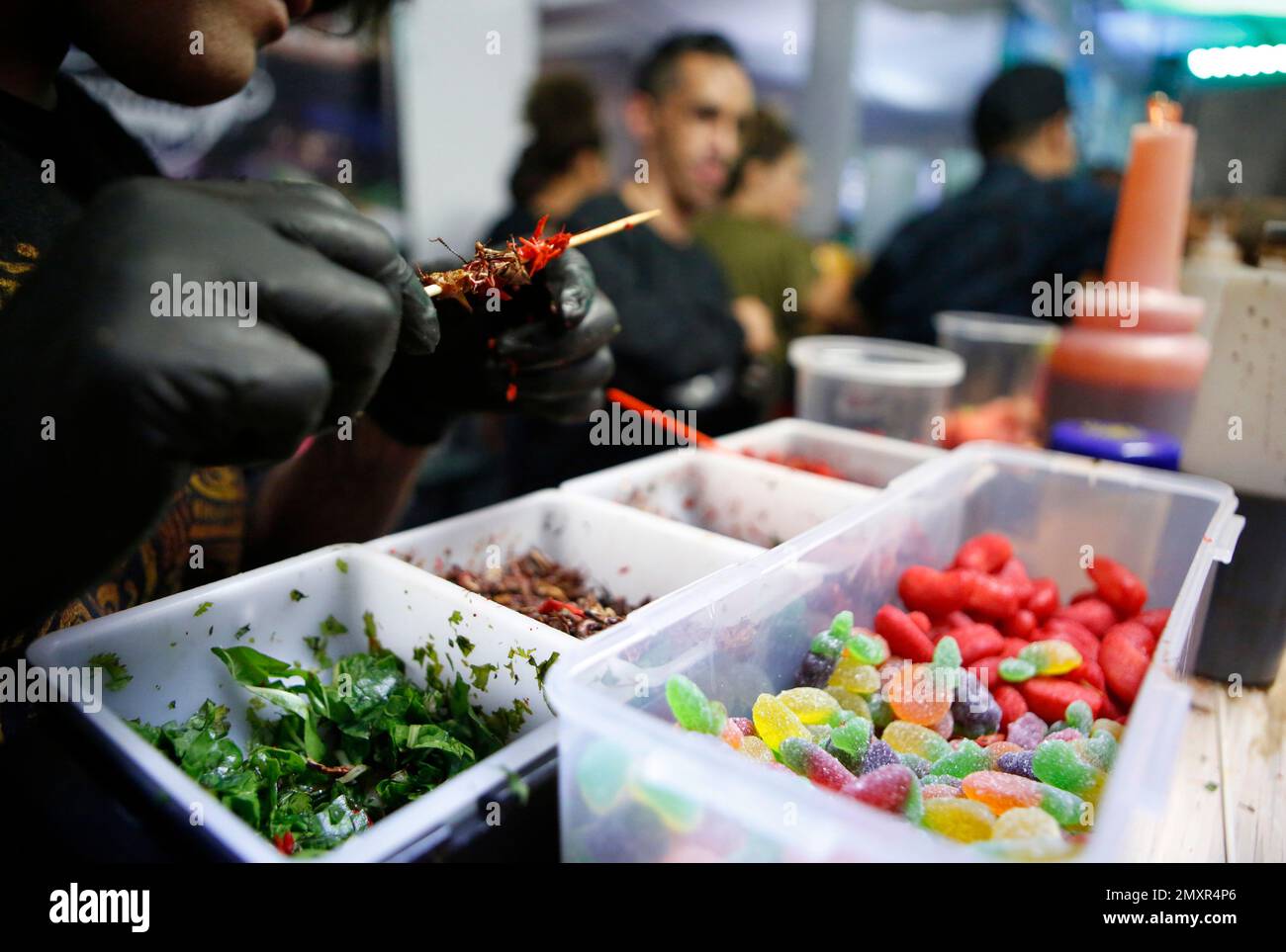 A worker prepares skewers of whole and tiny crayfish for