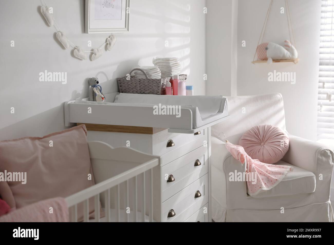 Chest of drawers with changing tray and pad in baby room. Interior