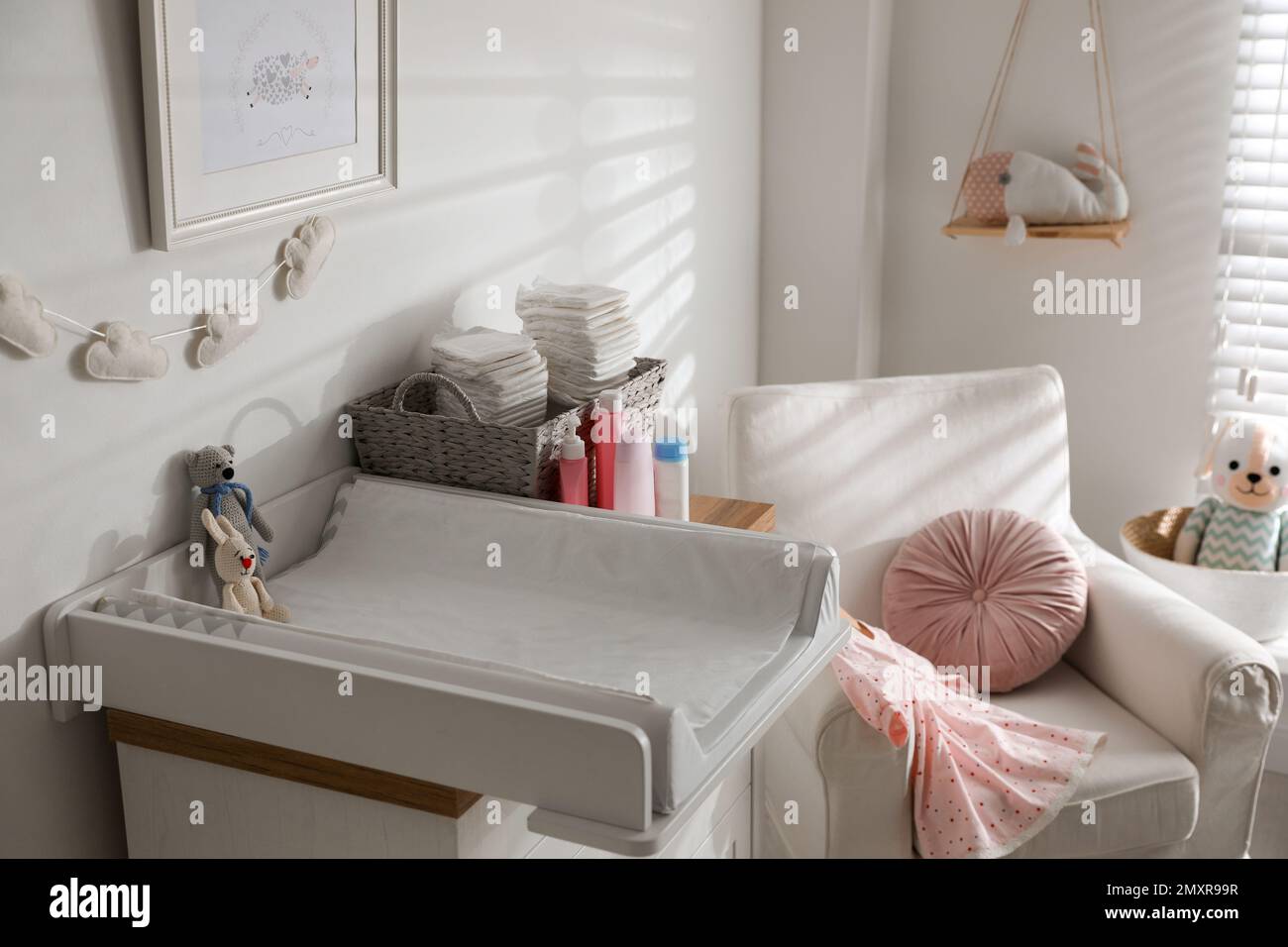 Chest of drawers with changing tray and pad in baby room. Interior