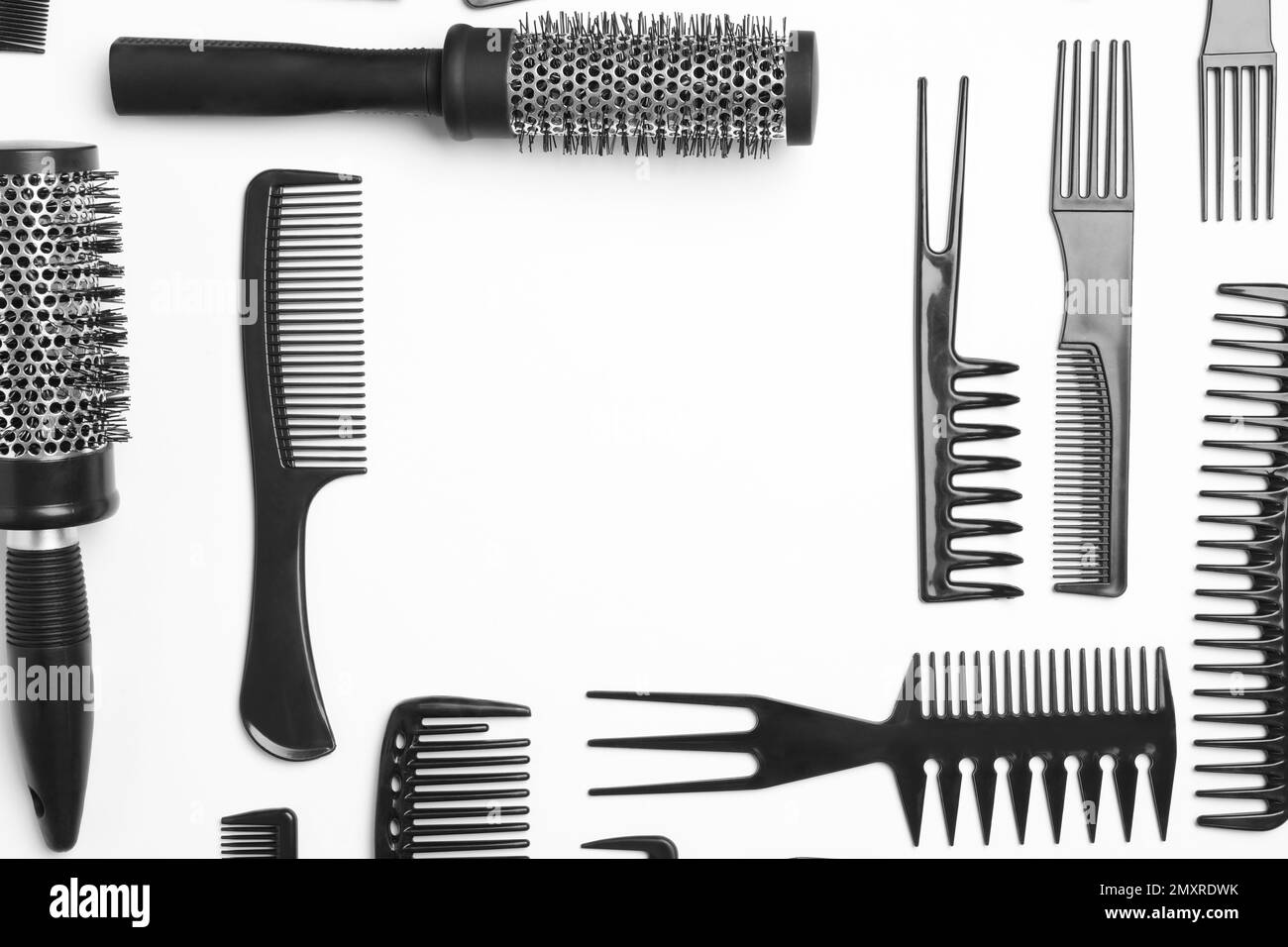 Frame of hair combs and brushes on white background, top view. Space