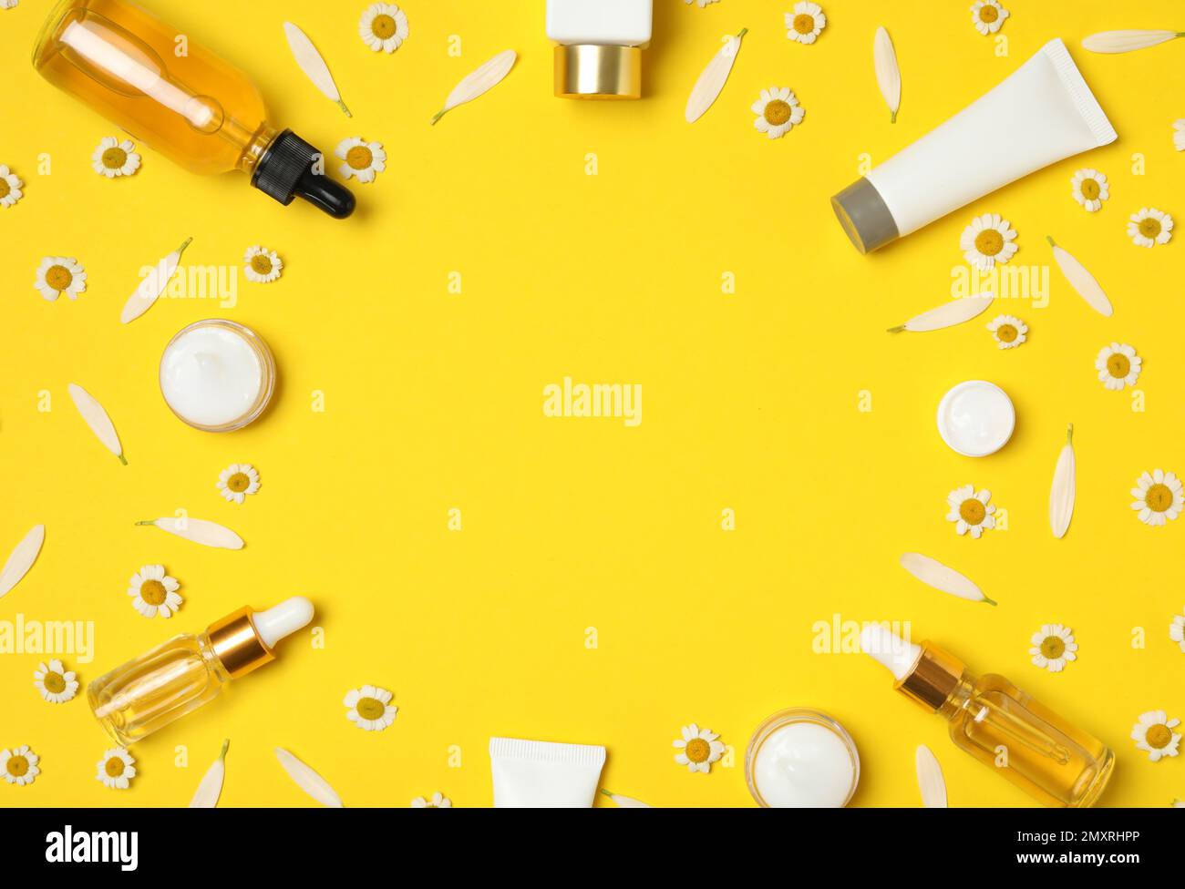 Flat lay composition with chamomiles and cosmetic products on yellow ...
