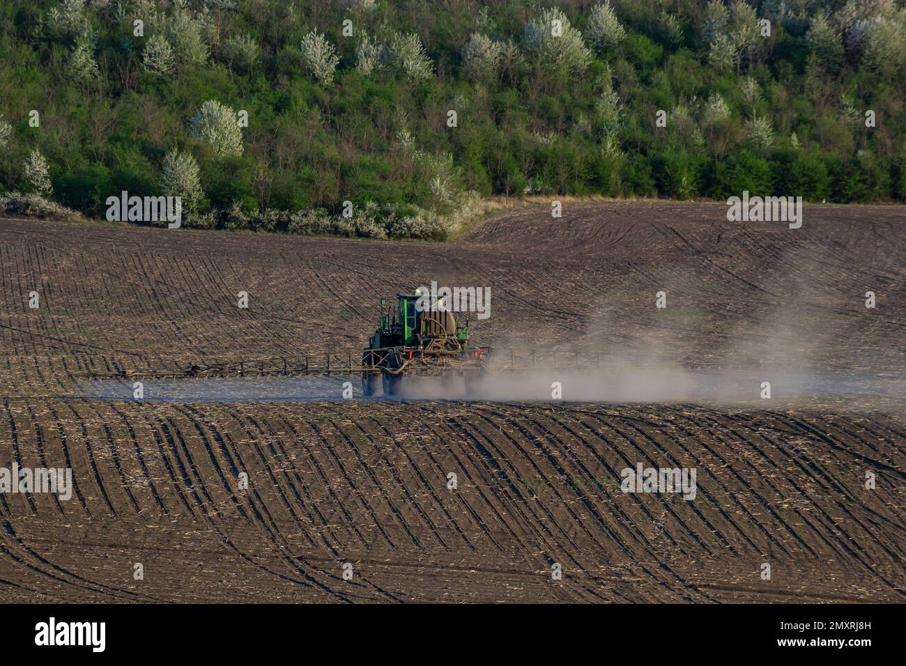 Tractor spray fertilizer spraying pesticides on green field