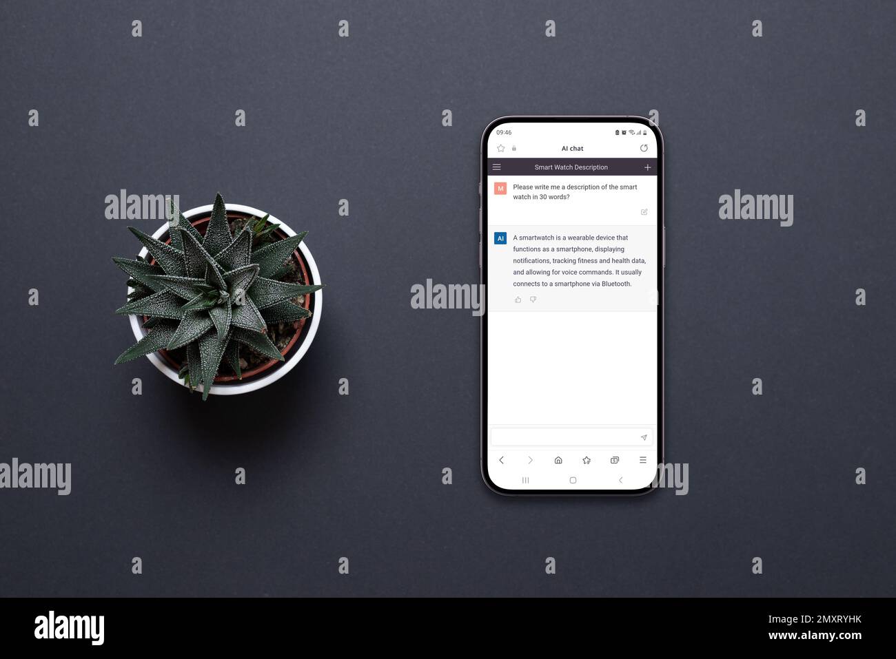 Mobile phone on the desk with a chatbot AI app. Conceptual design of app to communicate with artificial inteligence. Plant beside, top view, flat lay Stock Photo
