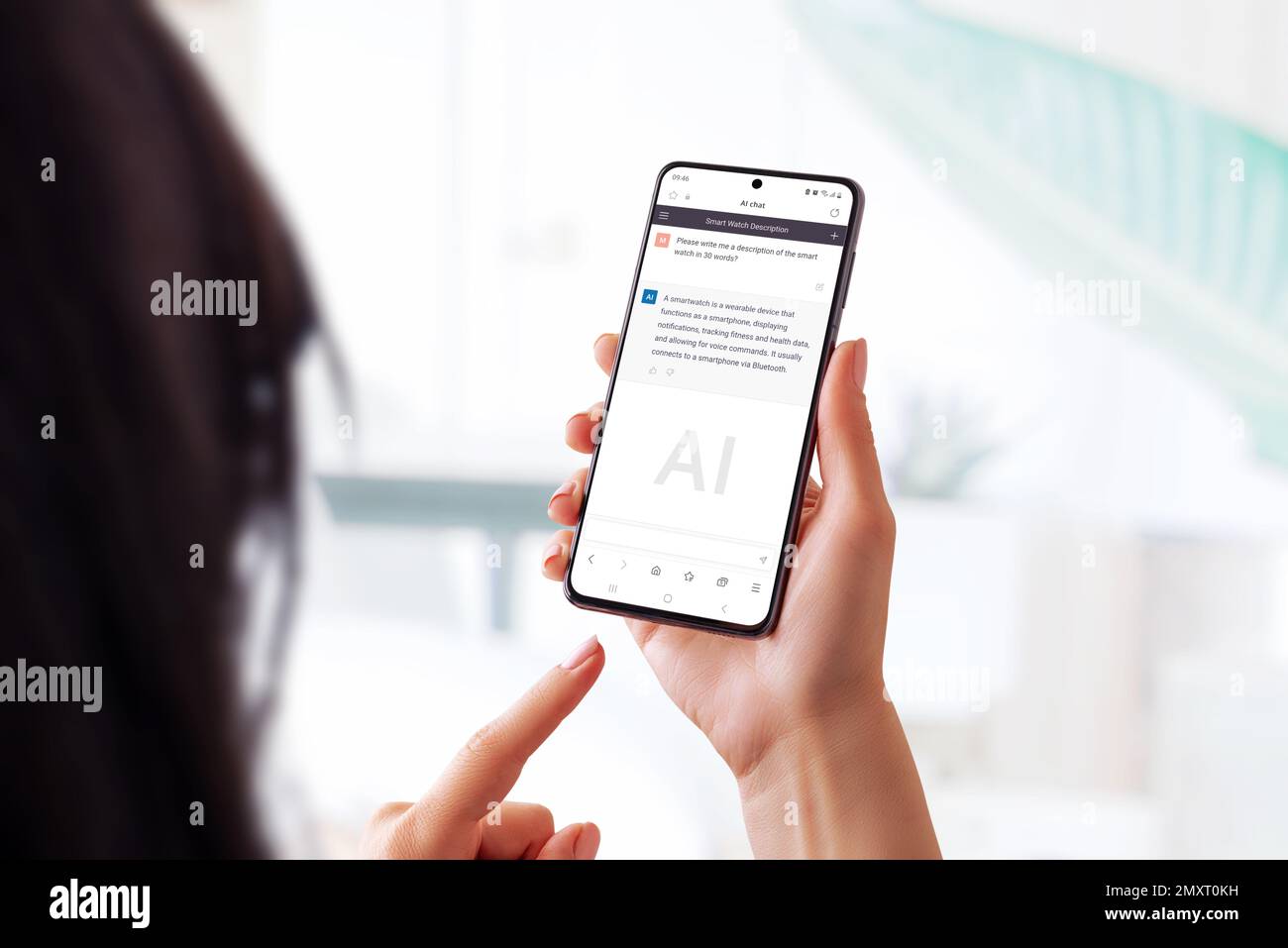 Woman holding a smart phone and using a chat bot app to ask questions about a smart watch. Showcases the use of AI language models to provide accessib Stock Photo