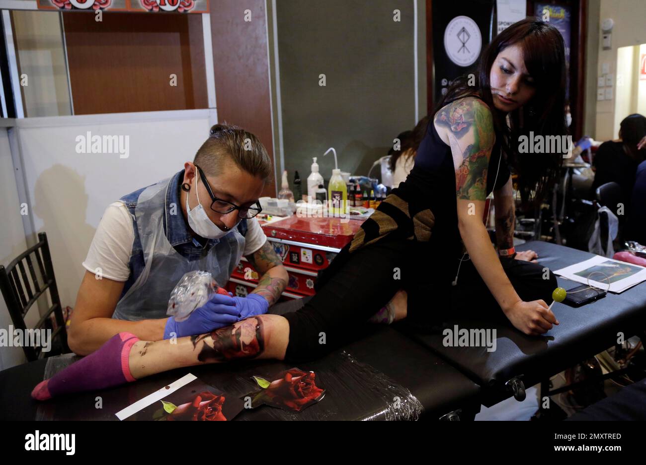 Xavo Padilla tattoos a flower on Michele’s calf with a flower design at