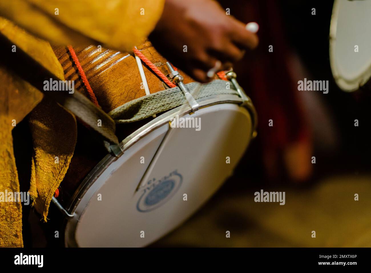 Dhool Instrument A man holds a stick with his hands to play the traditional dhol drum ...