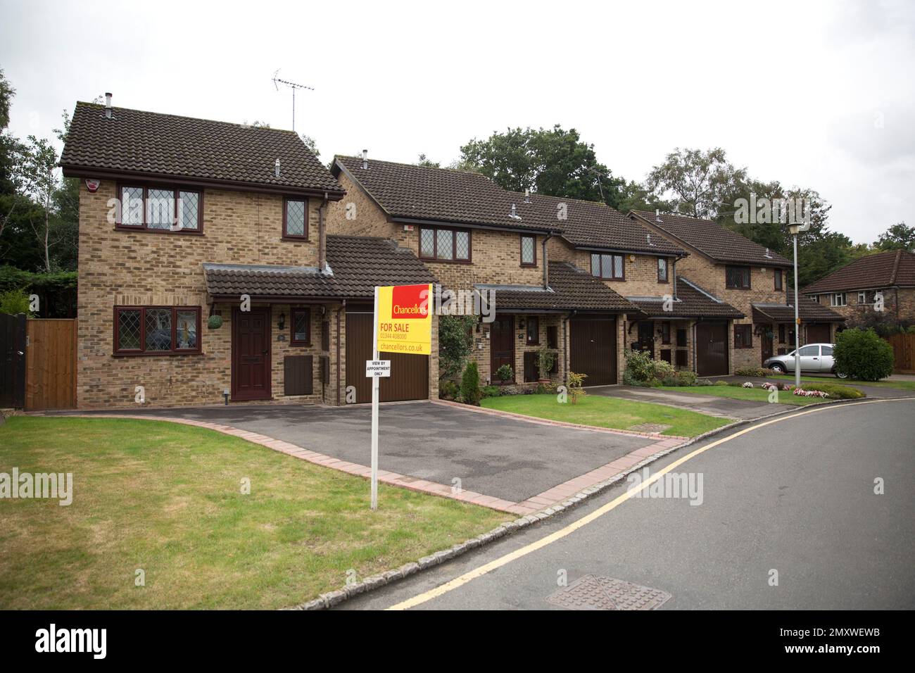 An exterior view shows at left, the house for sale that starred