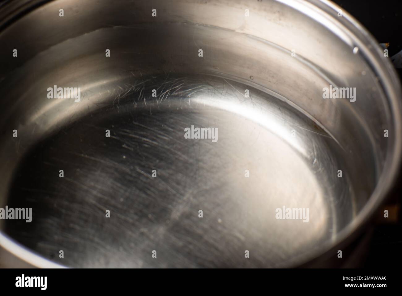 Water in a pot is on the stove in the kitchen. Preparation for boiling water. Stock Photo