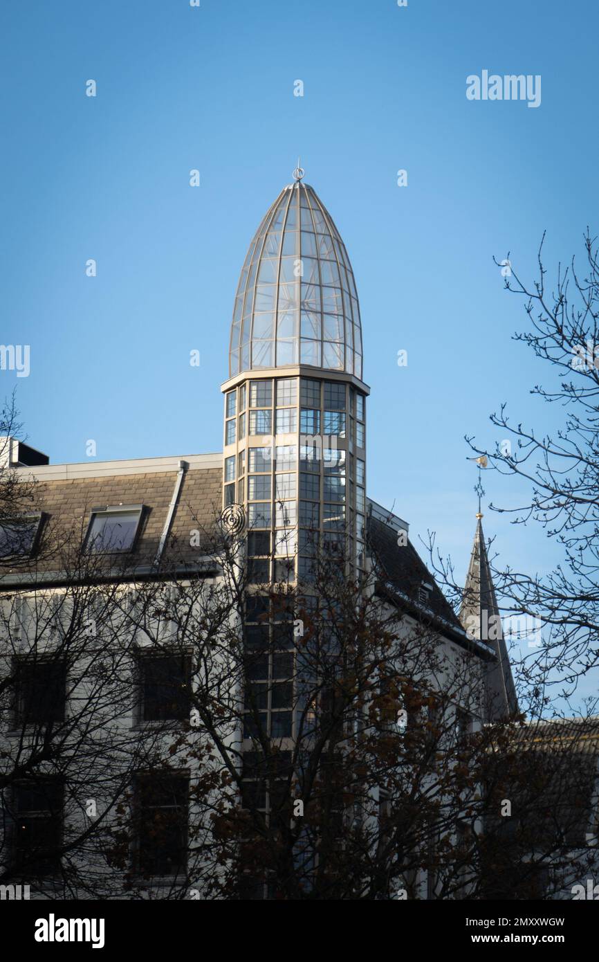 A vertical shot of a building with a glass domed tower against a clear blue sky Stock Photo
