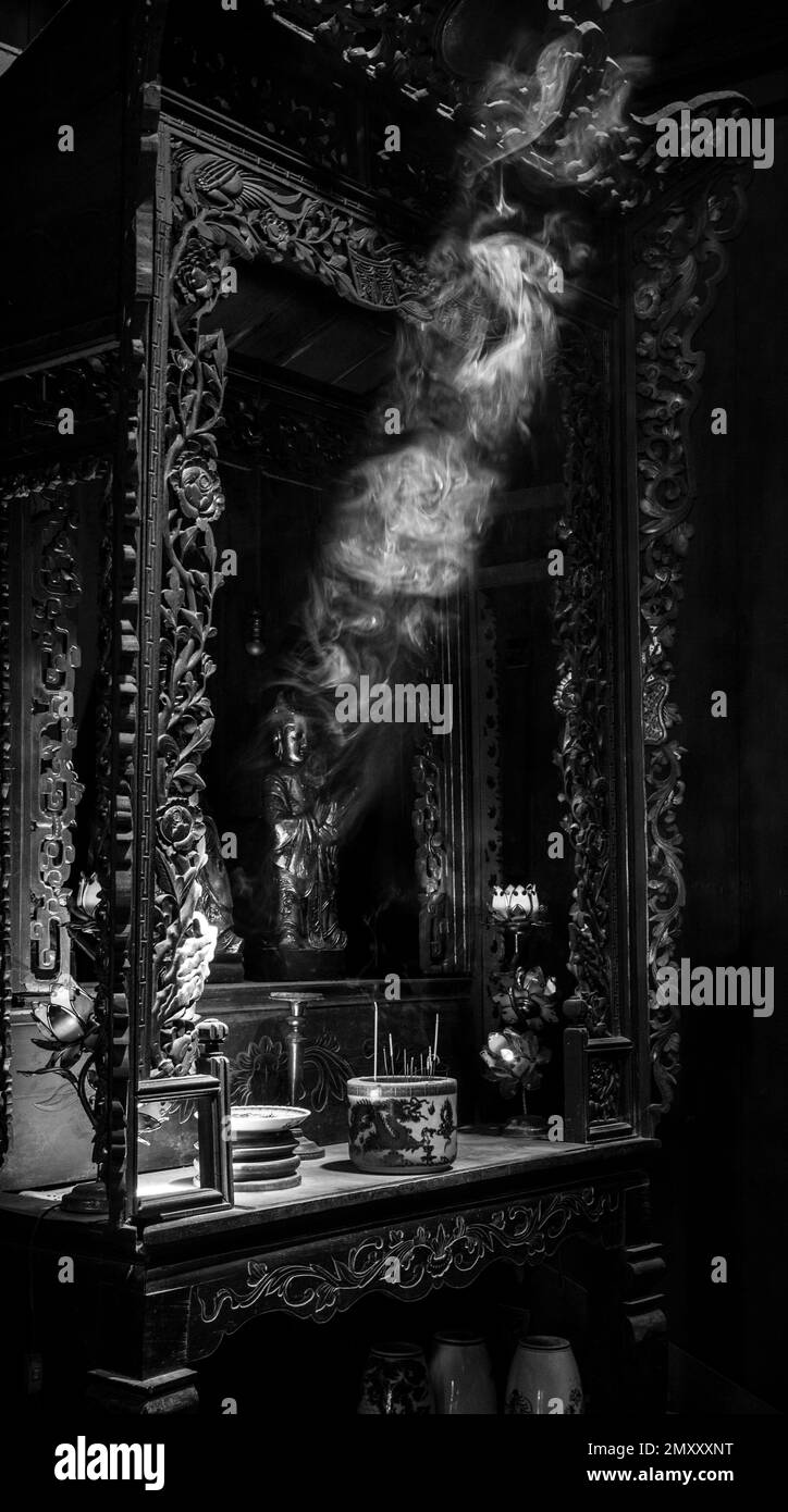 Incense smoke in a temple with ray of light on an altar in Buddhist temple. Stock Photo