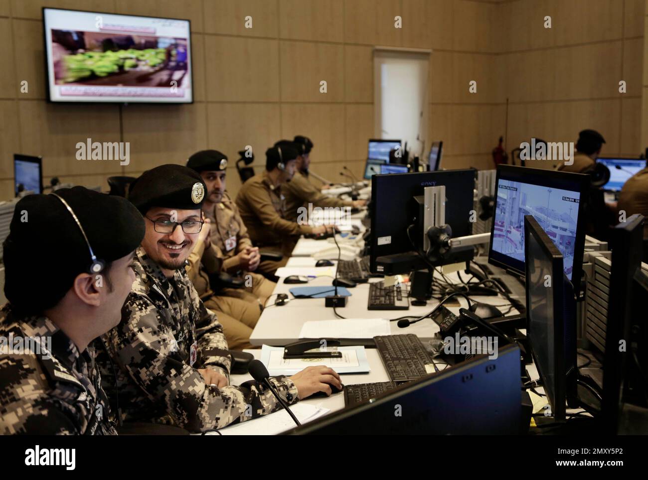 Saudi security officers monitor live feed screens showing Muslim ...