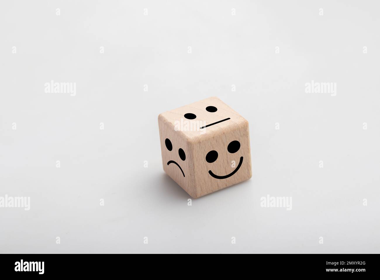 Mental health and emotional state concept, Smile face in bright side and sad face in dark side on wooden block white background Stock Photo