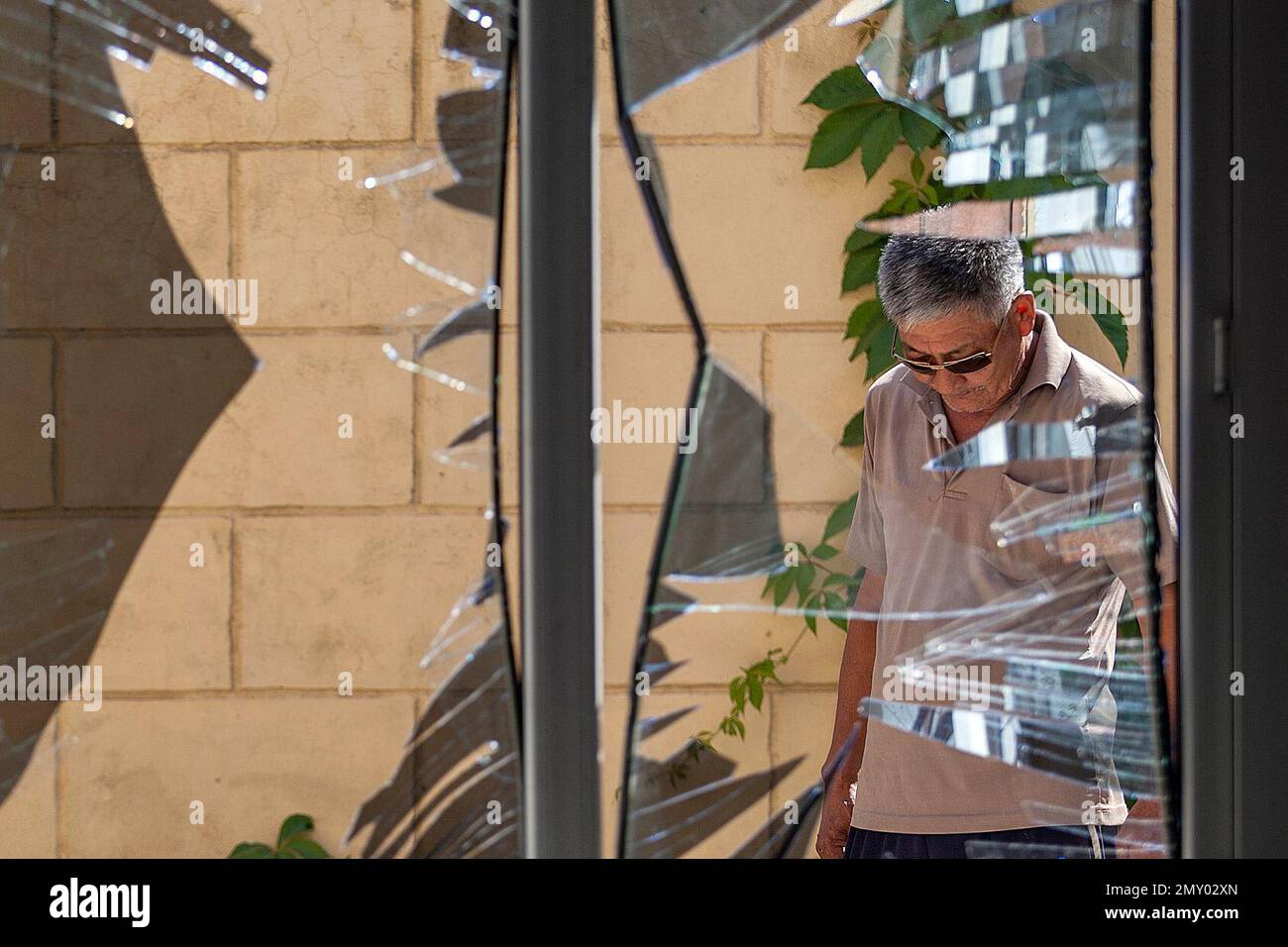 FILE - In this Aug. 30, 2016, file photo, a Chinese Embassy employee examines broken windows at the Chinese Embassy after a suicide bombing in Bishkek, Kyrgyzstan. The suicide bombing of the embassy highlighted the expanding threat of an ethnic Uighur militant group called the East Turkestan Islamic Movement - and the growing Chinese involvement in Syria and Afghanistan to combat it. The ETIM, also known as the Turkistan Islamic Party, has sought for decades to establish an independent state in China’s far west for the repressed Muslim Uighur minority. (AP Photo/File) Stock Photo