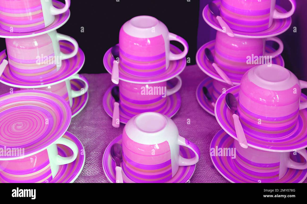 Stacks of cups and saucers in dreamy purple pink color tone Stock Photo