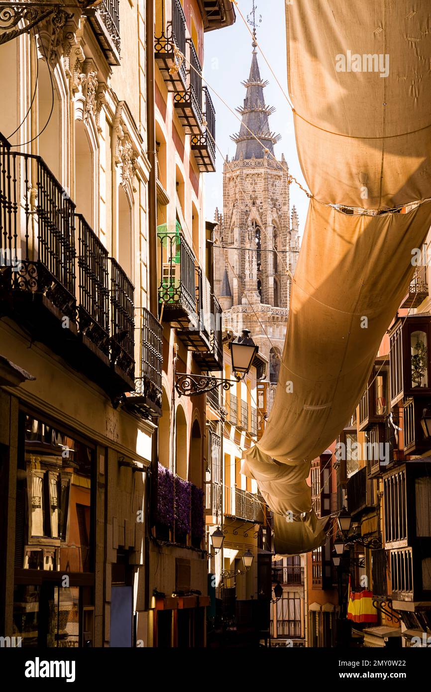 Narrow alleys of Toledo with shade cover and view of the bell tower of