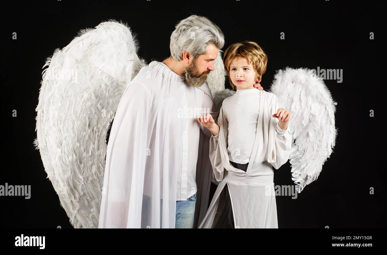Valentines day. Father and son in angel wings. Little cupid boy and bearded man in white clothes. Stock Photo
