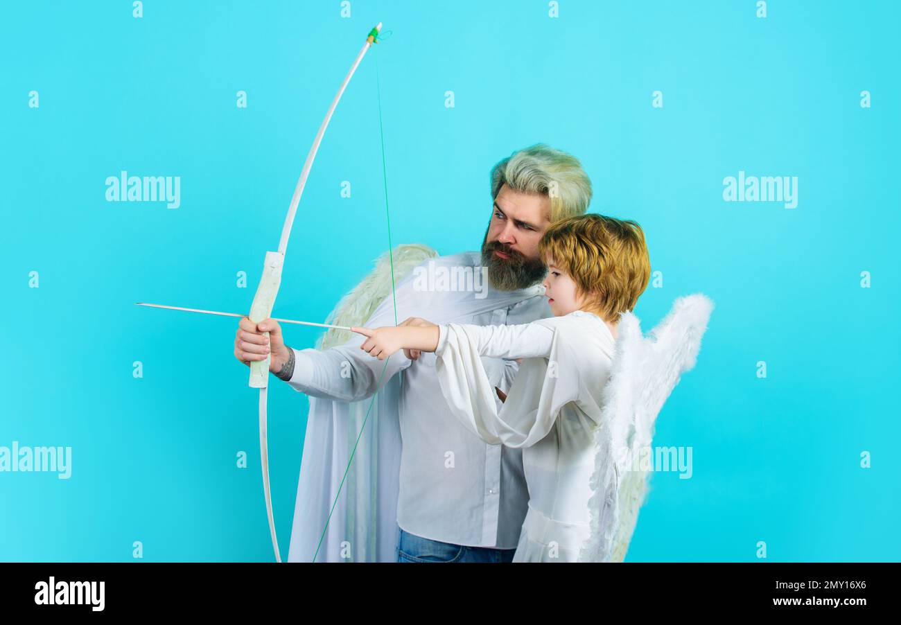 Valentines day. Little cupid boy and father in angel costume with bow and arrow. Christmas angels. Stock Photo