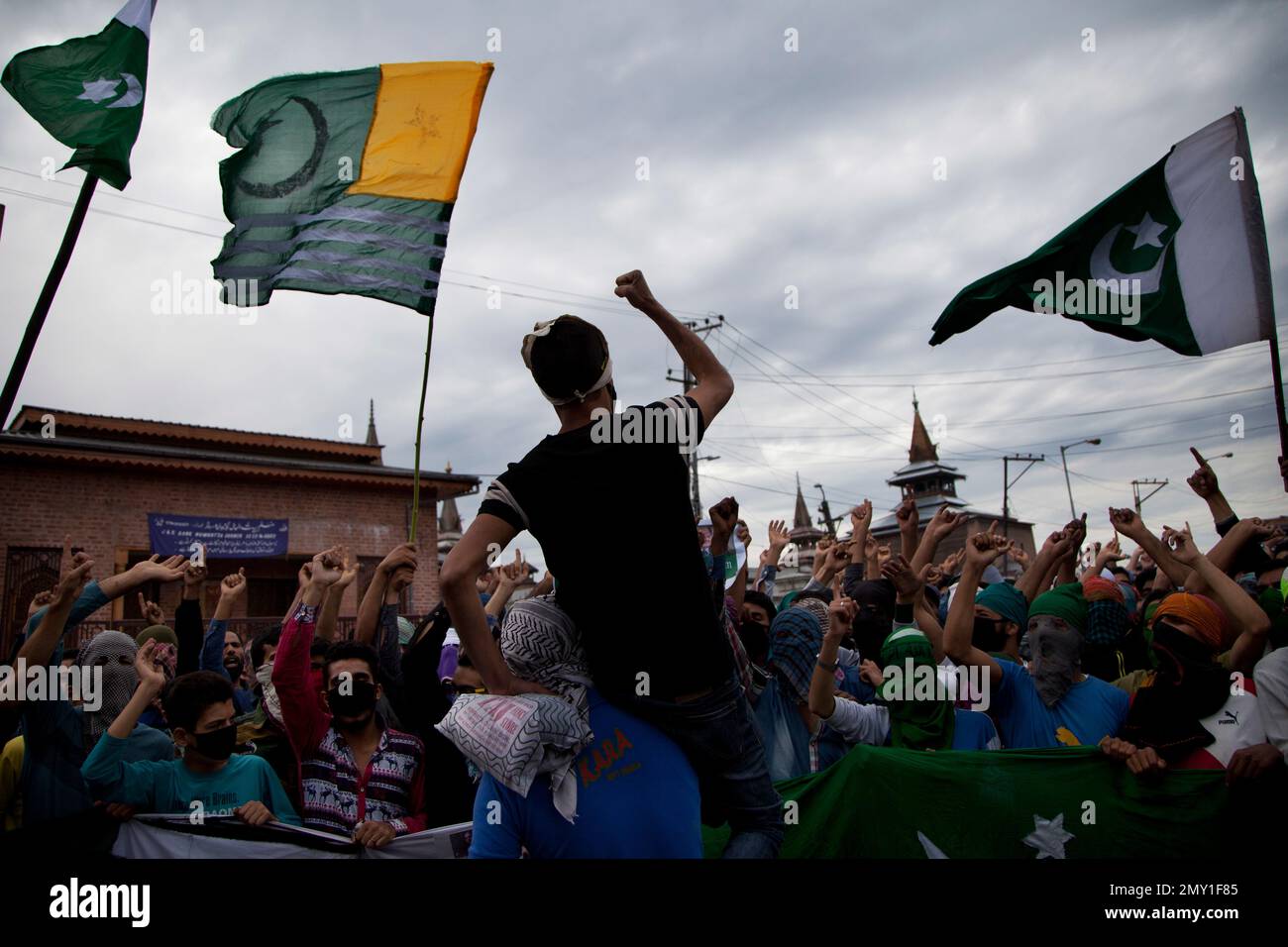 Kashmiri protesters carrying Pakistani flags and a flag of Pakistan ...