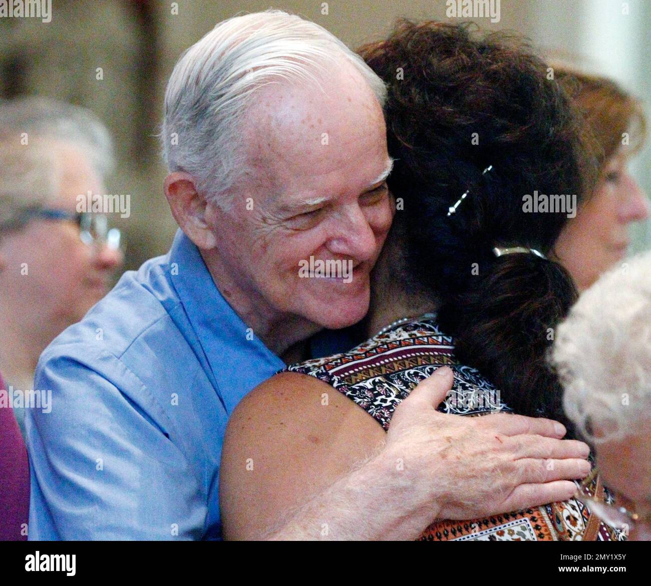 John Merrill, the older brother of Sister Paula Merrill, left, hugs a